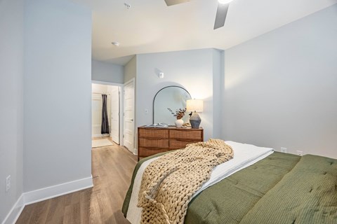 a bedroom with a bed and a dresser with a mirror