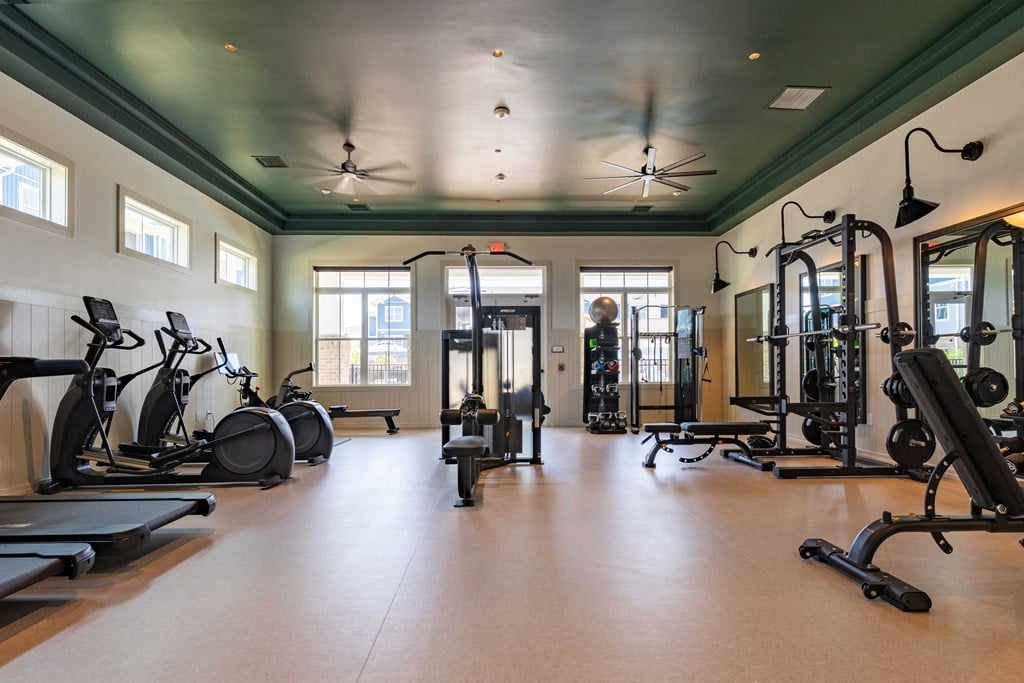 a workout room with exercise equipment and windows