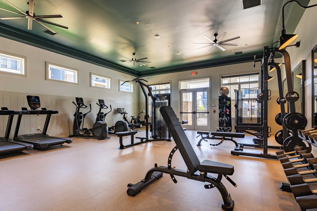 a gym with weights and other exercise equipment and windows