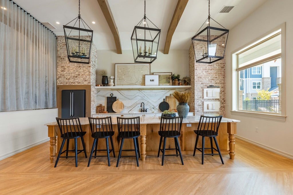 a dining room with a long wooden table and chairs in front of a fireplace