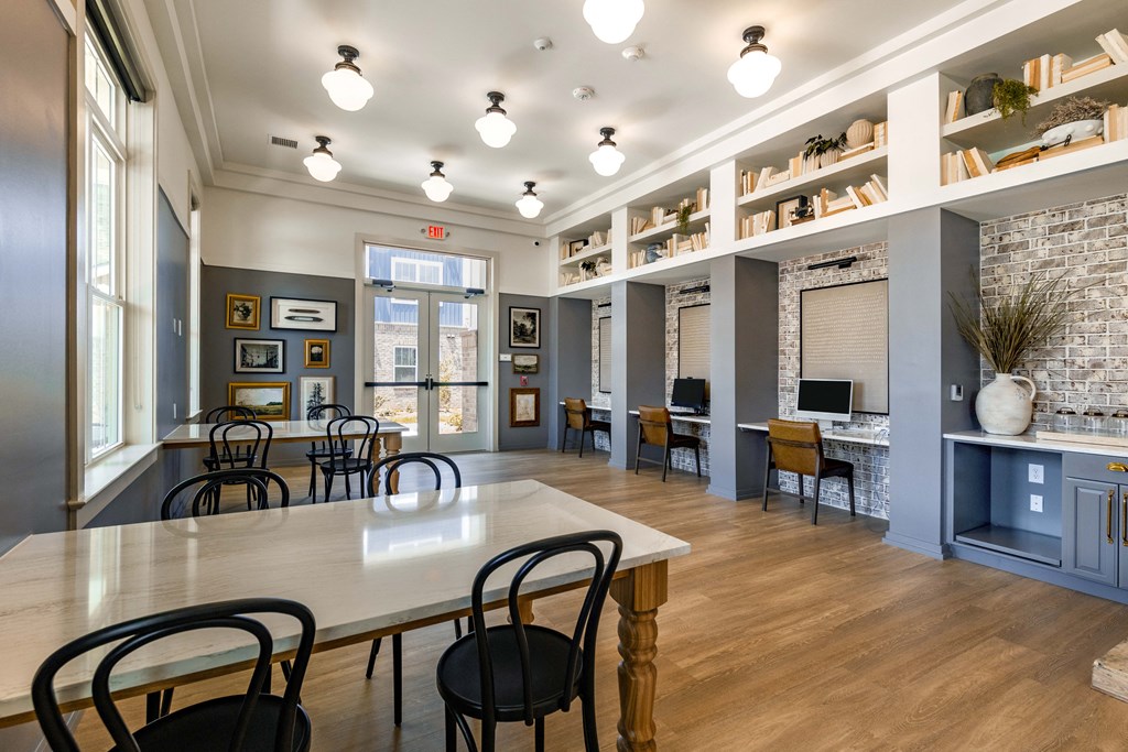 a large room with tables and chairs and a computer