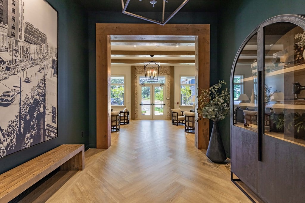 a long hallway with wood floors and a black and white photo on the wall