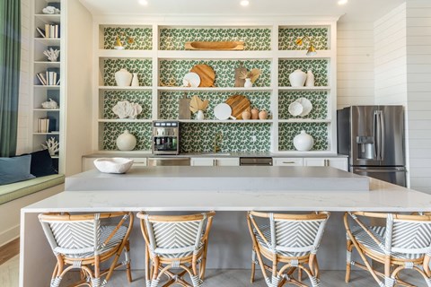 a kitchen with a large island with four chairs