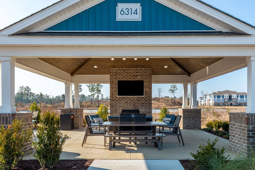 a covered patio with a table and chairs and a tv