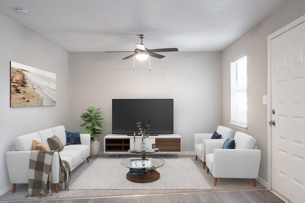 a living room with white couches and chairs and a large tv on the wall