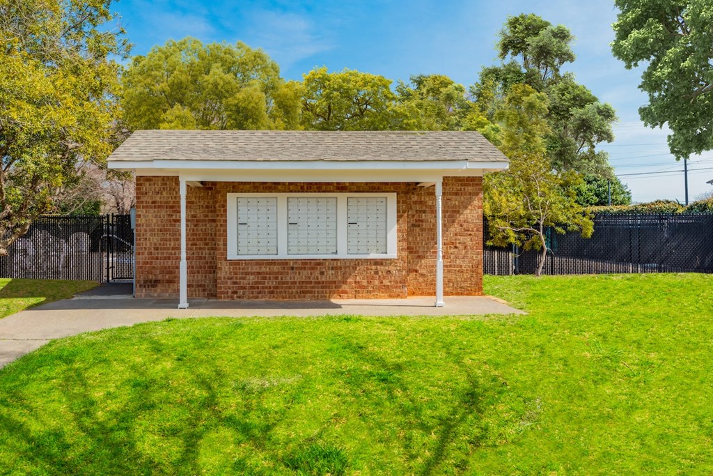 a small brick building with a lawn in front of it
