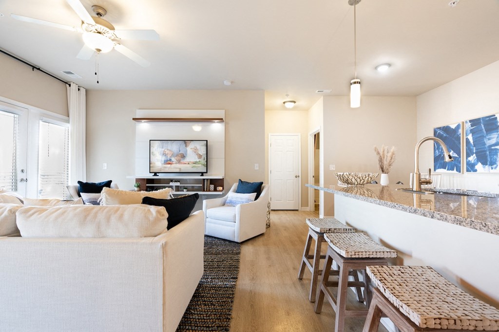 a living room and kitchen with a bar and couches