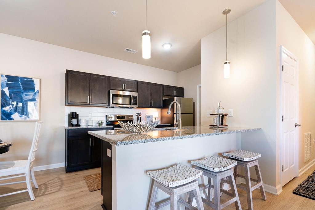 a kitchen with bar stools and a counter top with a sink