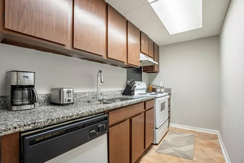 A kitchen with a black dishwasher and white oven.