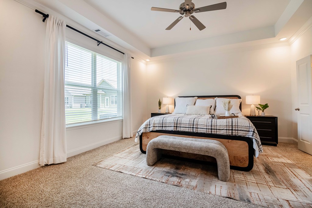 A bedroom with a large bed and a ceiling fan.