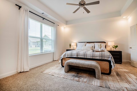A bedroom with a large bed and a ceiling fan.
