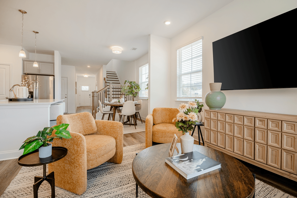 A living room with a brown sofa, a black coffee table, and a white wall.