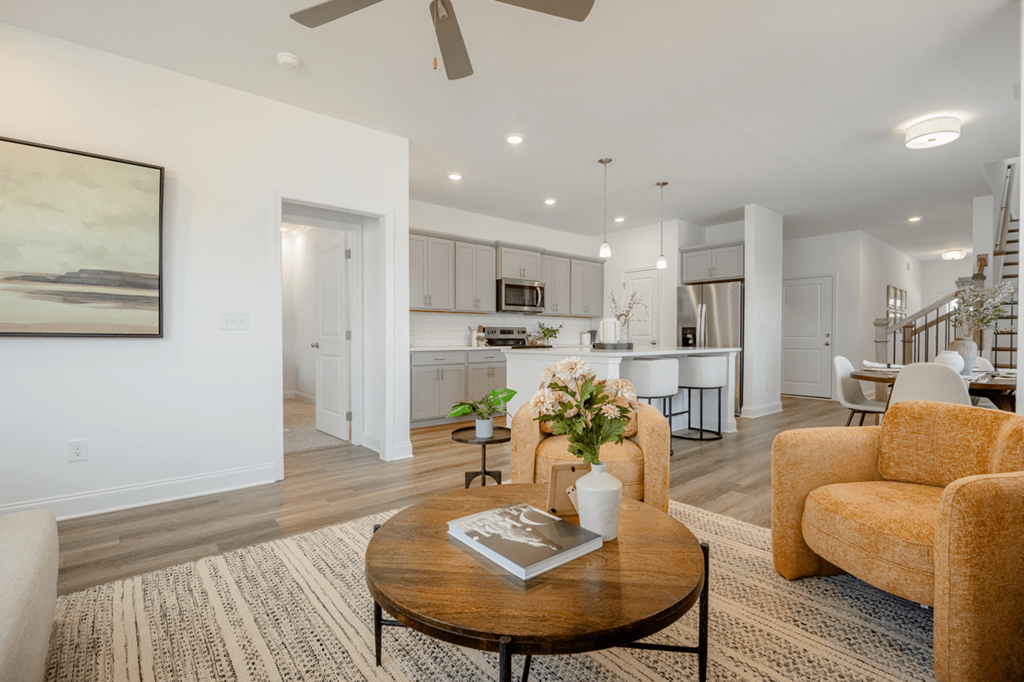 A living room with a brown coffee table and a painting on the wall.