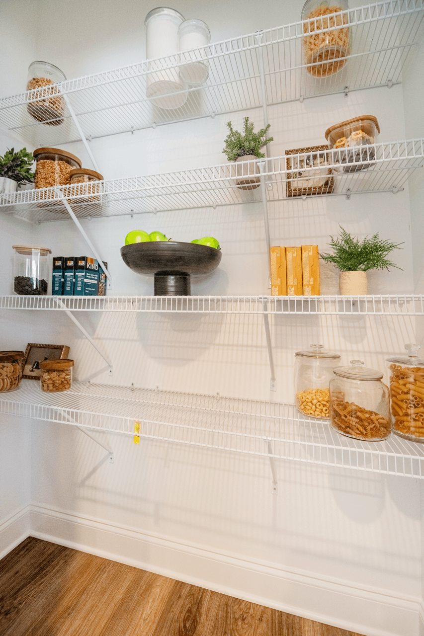 A white refrigerator with a bowl of fruit on the middle shelf.