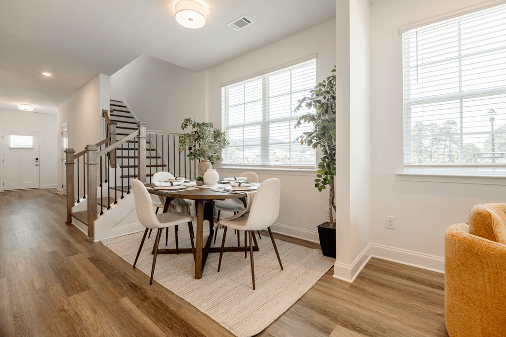 A dining room with a round table and chairs.
