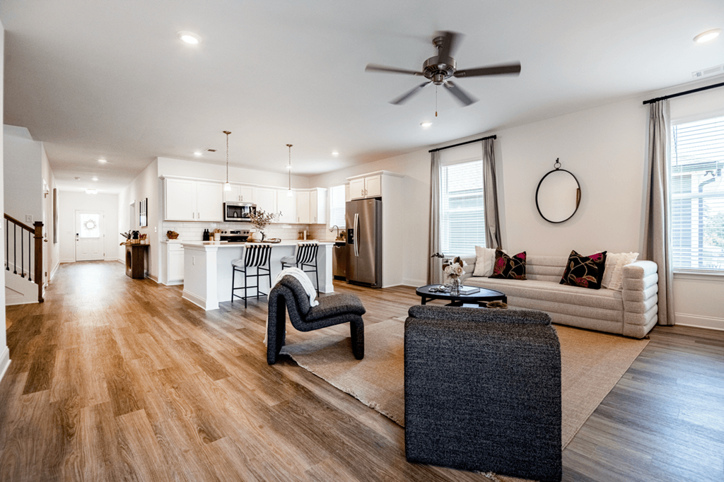 A modern living room with a dark grey sofa and a wooden floor.