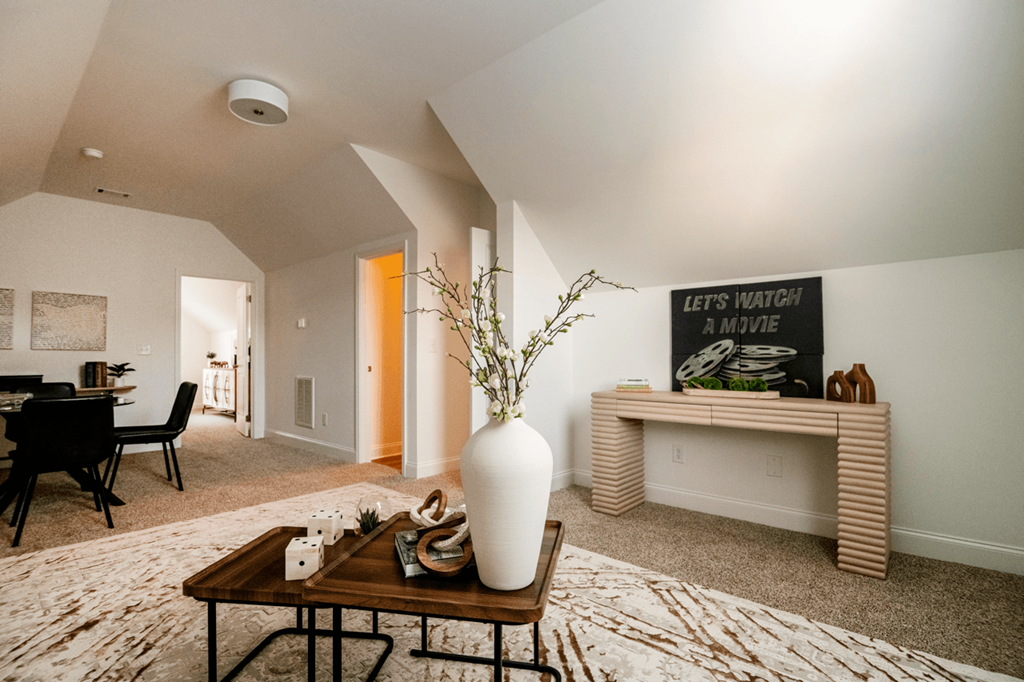 A living room with a coffee table and a vase on it.