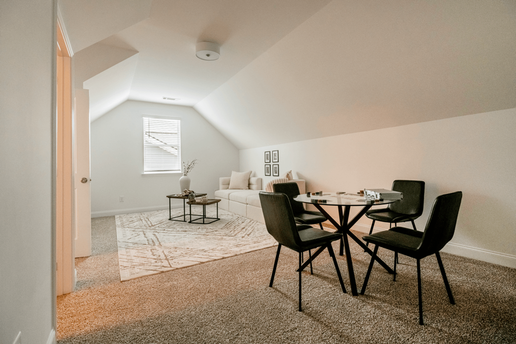 A dining room with a table and chairs.