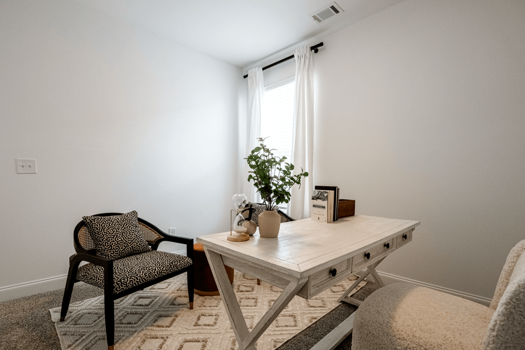 A room with a chair, table, and potted plant.