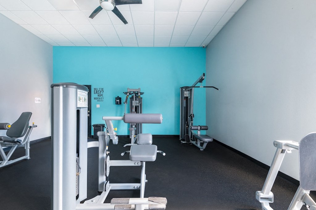 a gym with exercise equipment and a blue wall