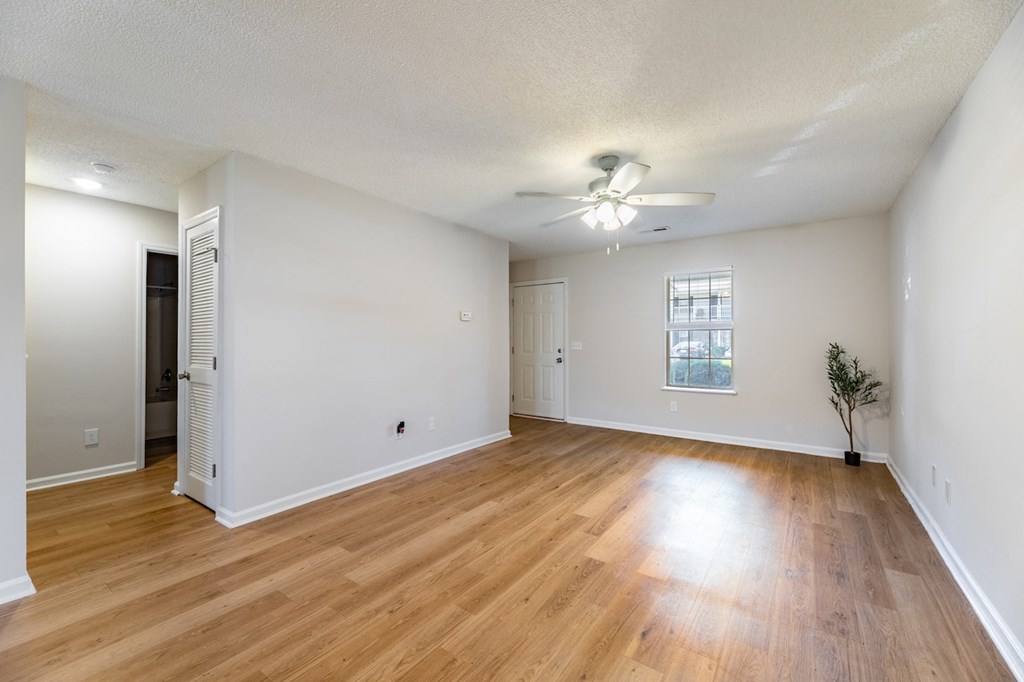 A room with wooden floors and a ceiling fan.