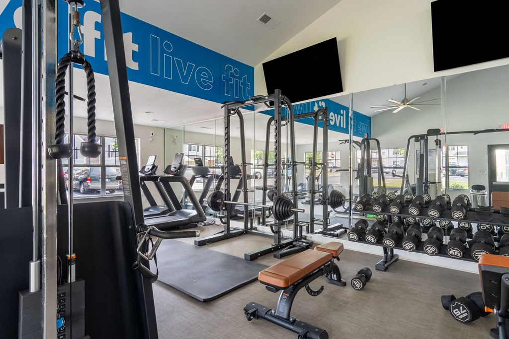 a spacious fitness center with cardio machines and weights