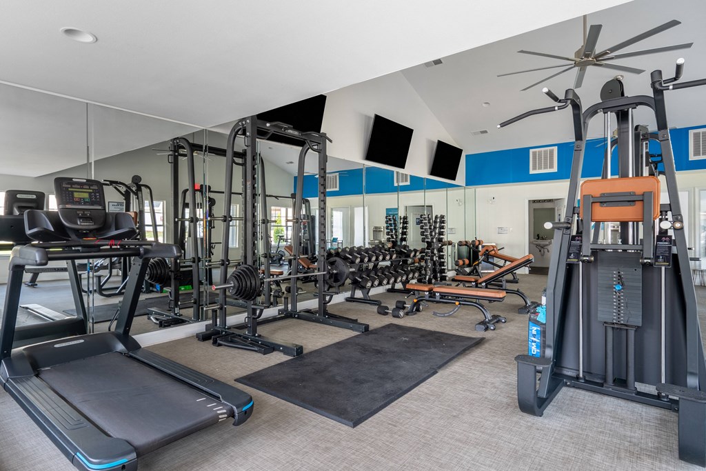 a spacious fitness center with cardio machines and other exercise equipment