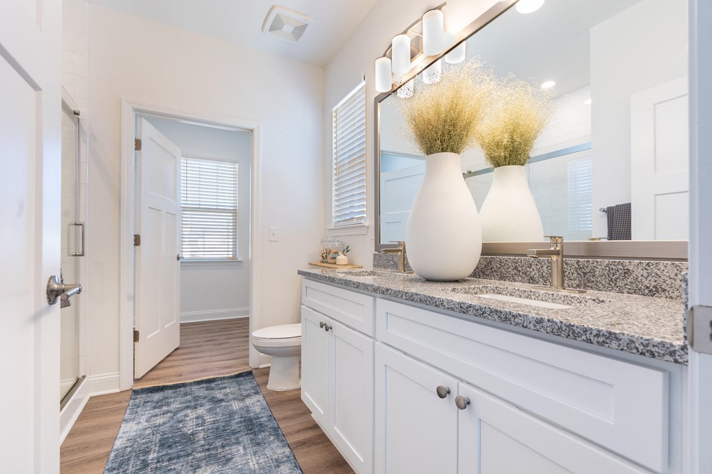 A spacious bathroom with a white vanity plenty of counter space