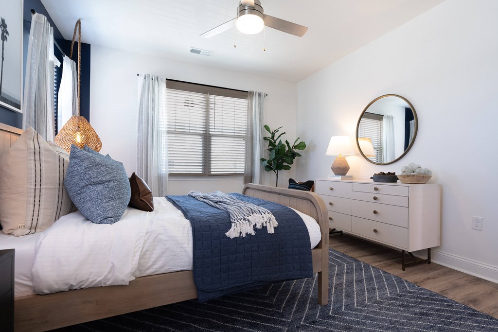 A bedroom with a bed, dresser, and mirror.