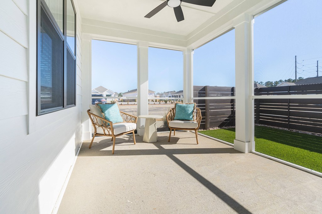 A patio with a ceiling fan and two chairs.