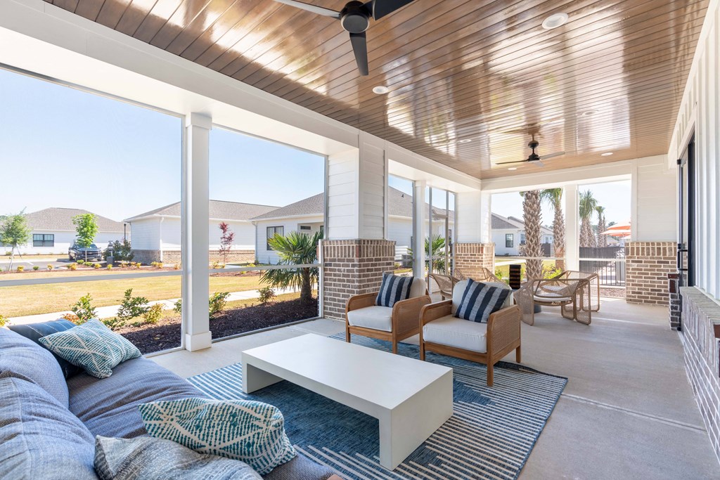 A patio with a white couch and a white coffee table.