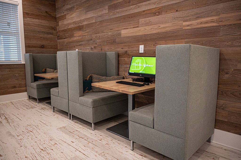 a room with two gray chairs and a desk with a computer