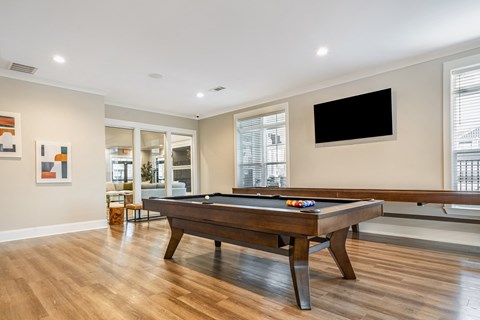 a game room with a pool table and a tv