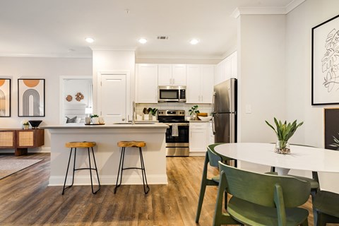 an open kitchen and dining area with a table and stools