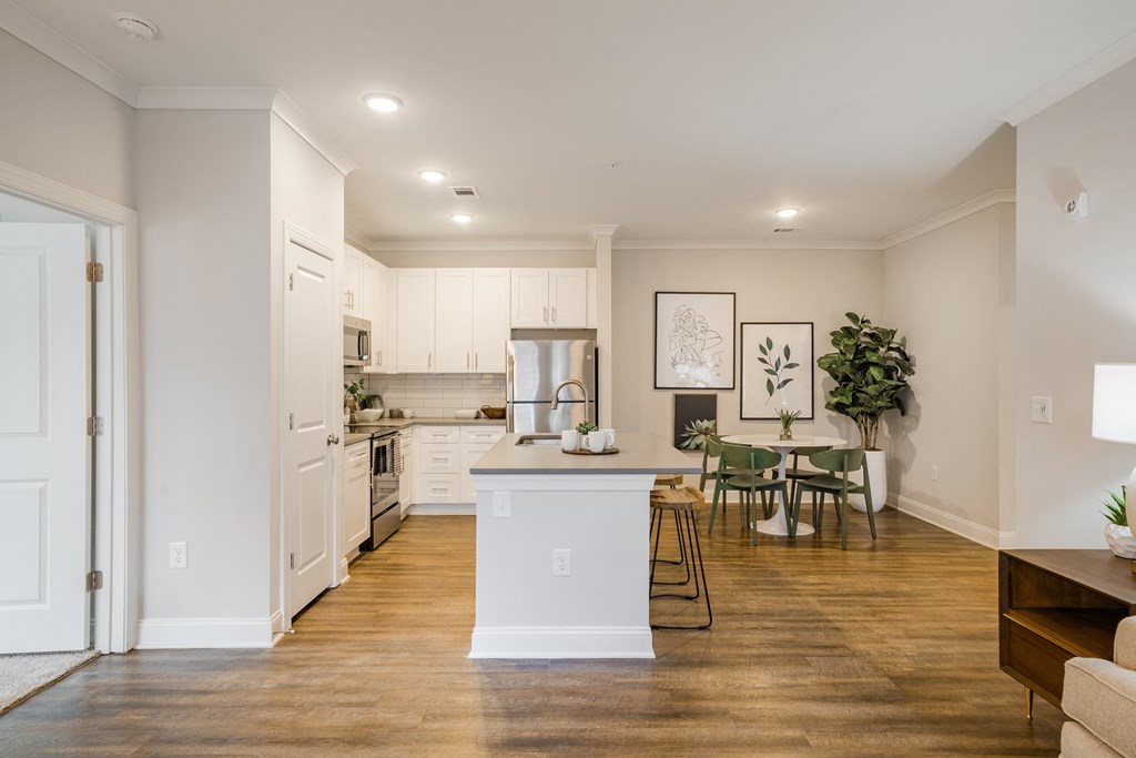 an open kitchen and living room with a dining area and a table with chairs