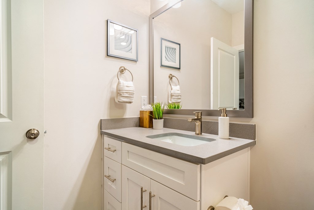 a white bathroom with a sink and a mirror