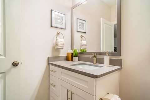 a white bathroom with a sink and a mirror