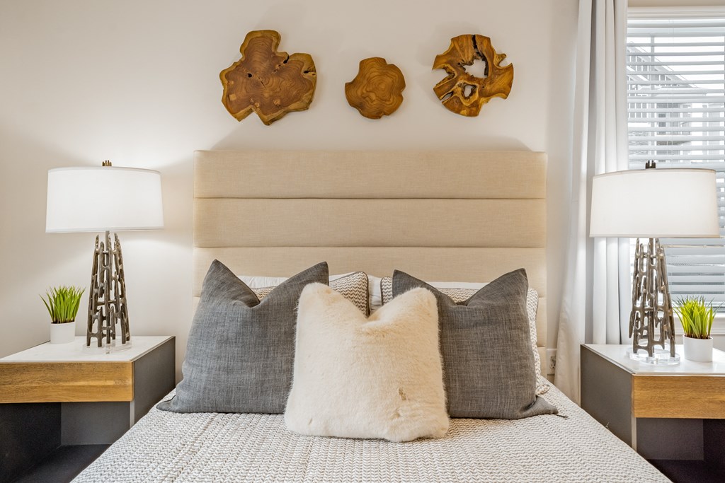 a bedroom with a bed with pillows and a wooden headboard