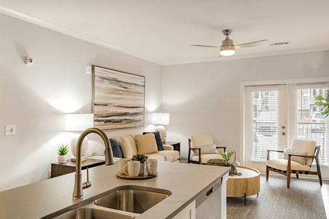 a living room with a kitchen counter top and a sink