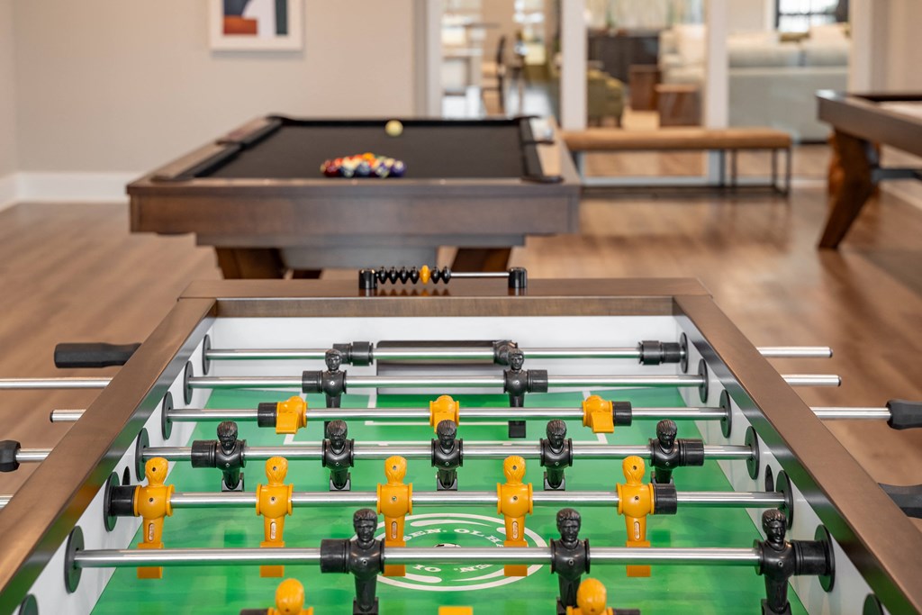 a foosball table in a living room with a pool table