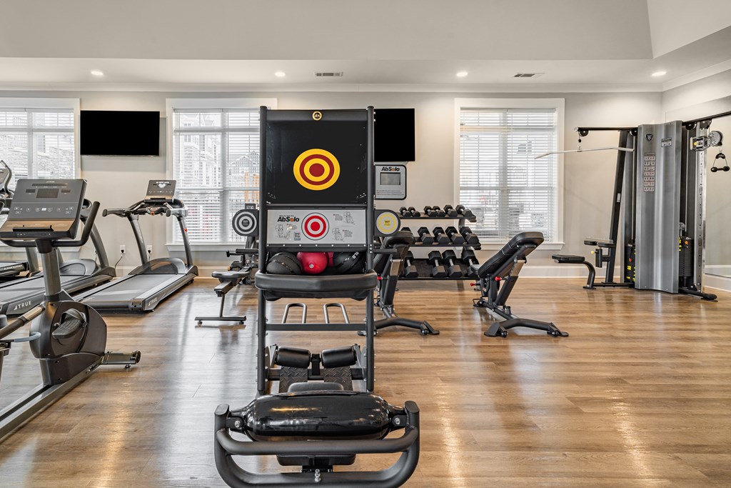 a gym with weights and a screen in the center of it