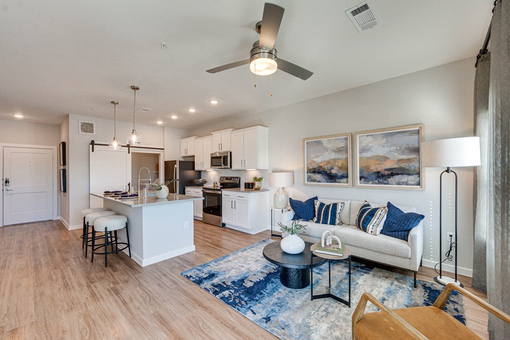 Open-Concept Living Room and Kitchen with White Cabinets and Stainless Steel Appliances