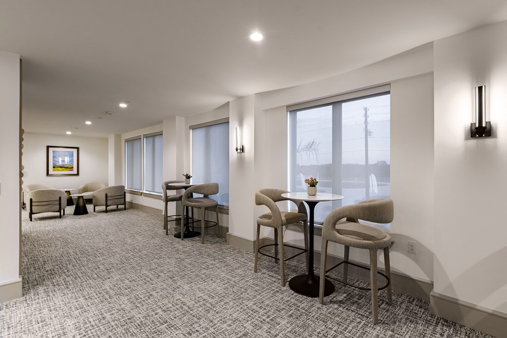 A grey and white waiting room with chairs and a table.
