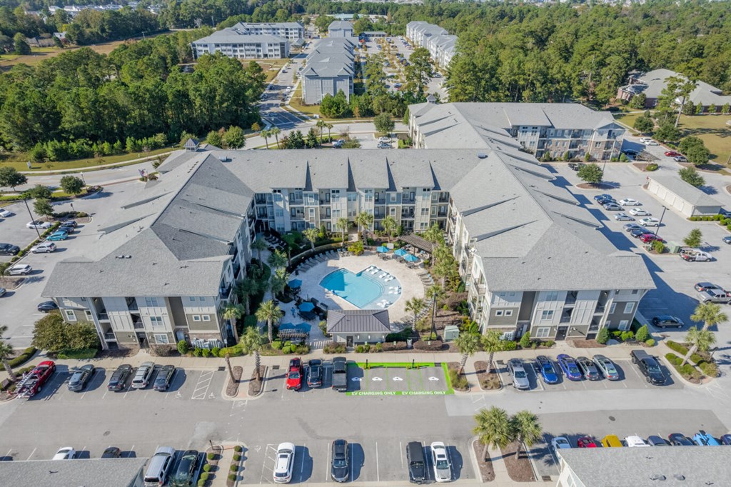 an aerial view of a building with a pool and parking lot