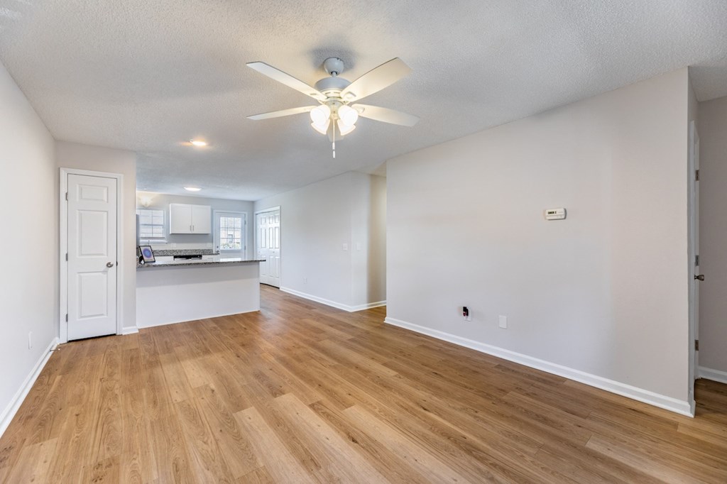A room with a ceiling fan and wooden flooring.
