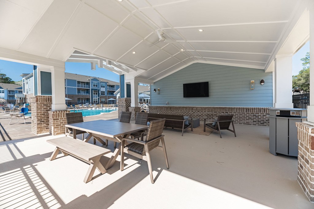 a patio with a table and chairs and a pool