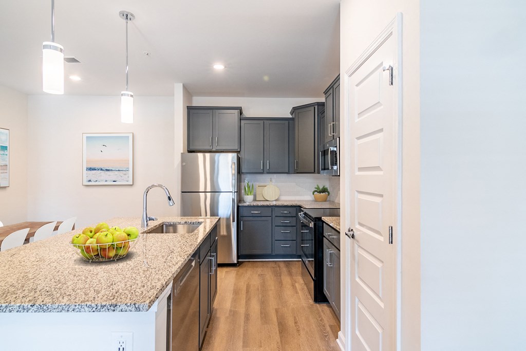 a kitchen with gray cabinets and a granite counter top