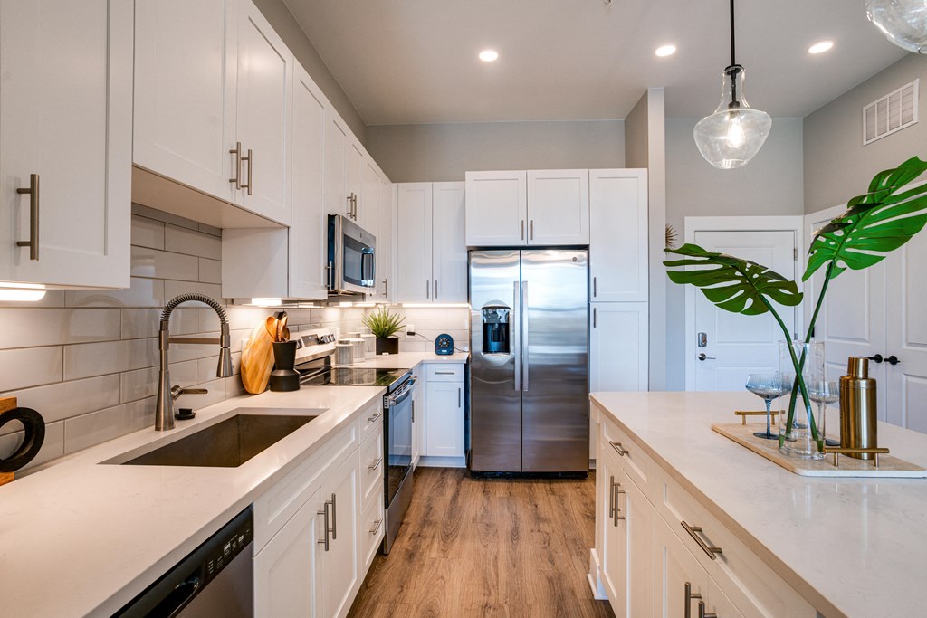 a kitchen with white cabinets and a stainless steel refrigerator