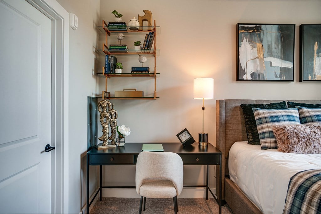 a bedroom with a bed and a desk with a chair