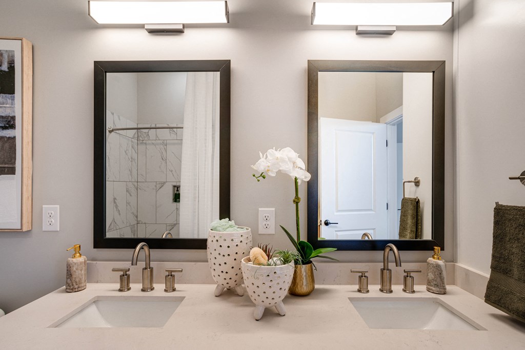 A bathroom with two sinks and a large mirror.